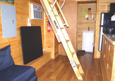 New River Tiny House hotel ladder to loft of tiny house with queen bed